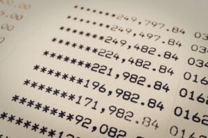 Close‑up of a financial statement showing a column of changing account balances, illustrating how unreconciled activity causes numbers to shift unexpectedly.