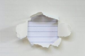 A sheet of paper torn open to reveal lined paper underneath, symbolizing missing or incomplete documentation.